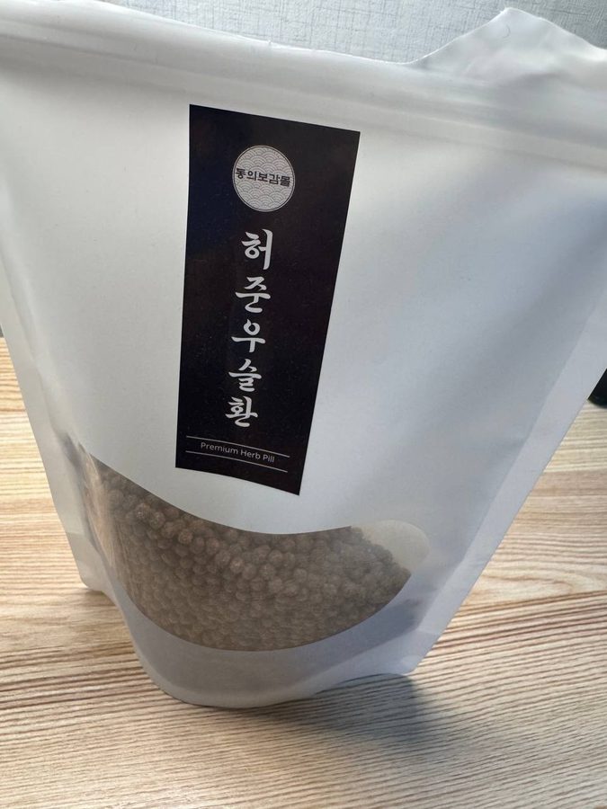 홍화우슬환 제품 패키지. 흰색 투명한 파우치에 검은색 라벨이 붙어 있다.